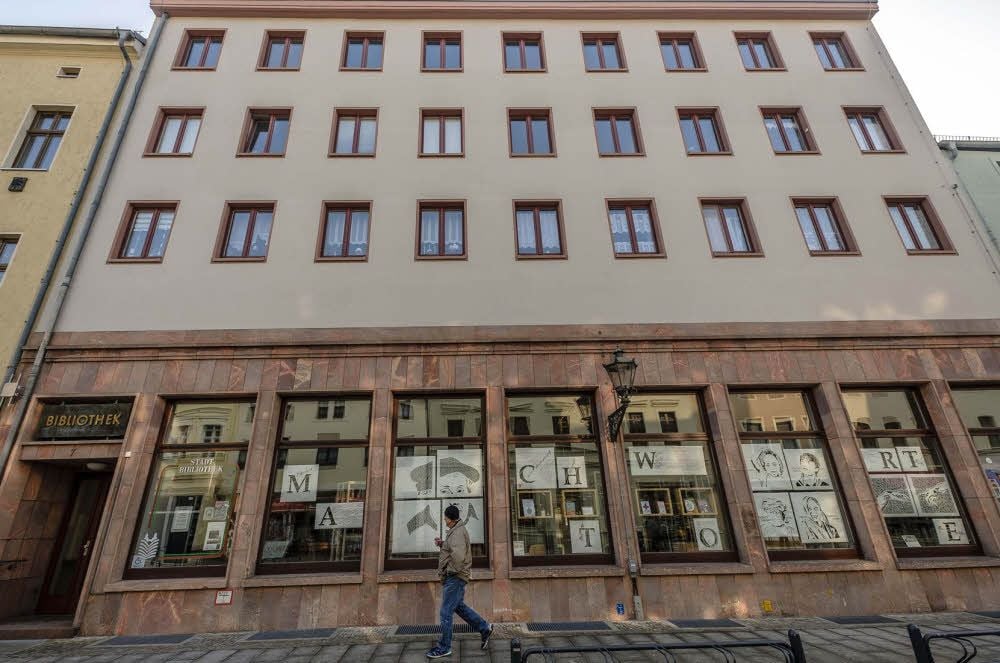 Scherenschnitte des Künstlerpaars Topanka-Freihube zieren derzeit die Fassade der Bibliothek. Mit dem Umbau wird der Eingang in die Mitte verlegt.
