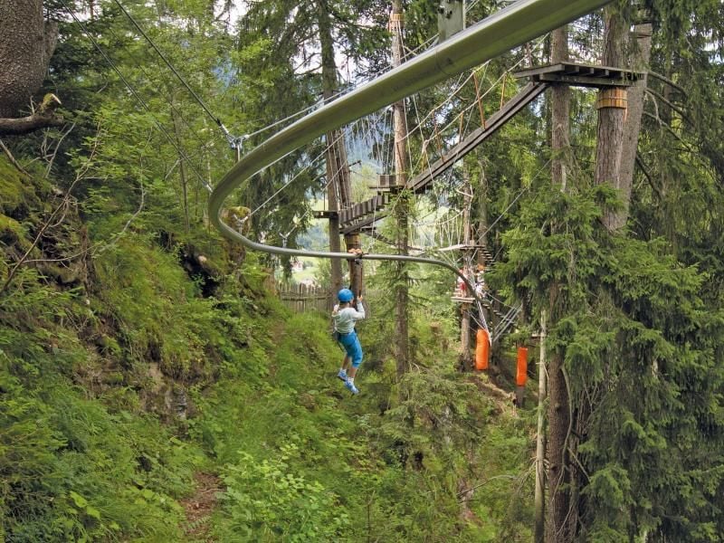 Eine junge Frau hängt in einer Baumschwebebahn. Foto: Hochkant/Archiv