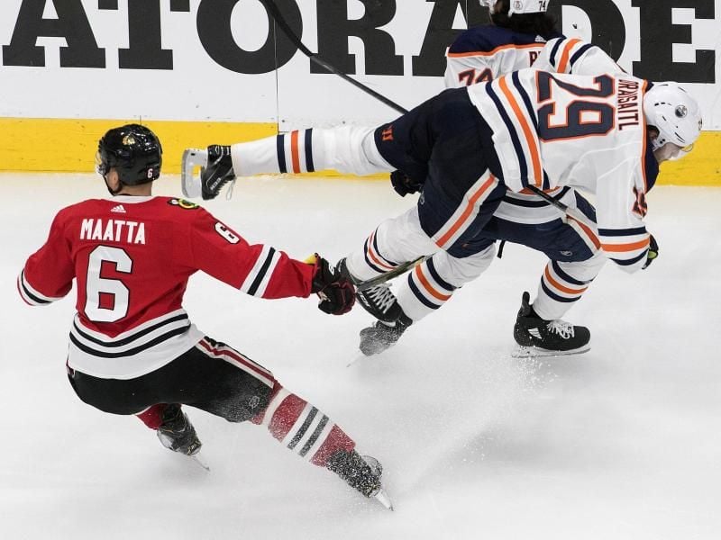 Edmontons Leon Draisaitl (r) wird durch Olli Maatta von den Chicago Blackhawks zu Fall gebracht. Foto: Jason Franson/The Canadian Press/AP/dpa