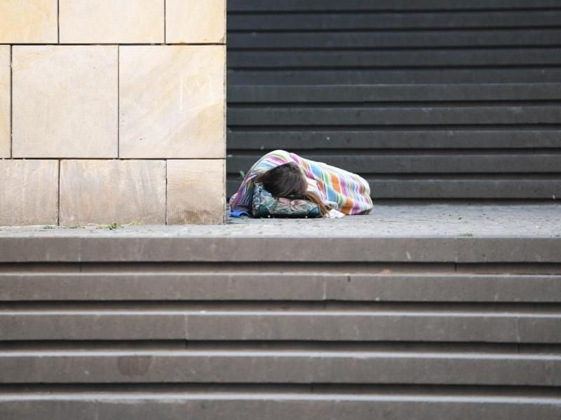 Eine Obdachlose schläft auf den Stufen vor der Kunsthalle Schirn in Frankfurt. Foto: Arne Dedert/Archivbild