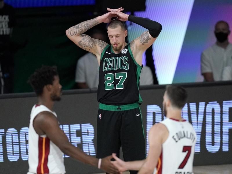 Daniel Theis (M) von den Boston Celtics legt die Hände über den Kopf und blickt zu Boden, während Jimmy Butler (l) und Goran Dragic von Miami Heat feiern. Foto: Mark J. Terrill/AP/dpa