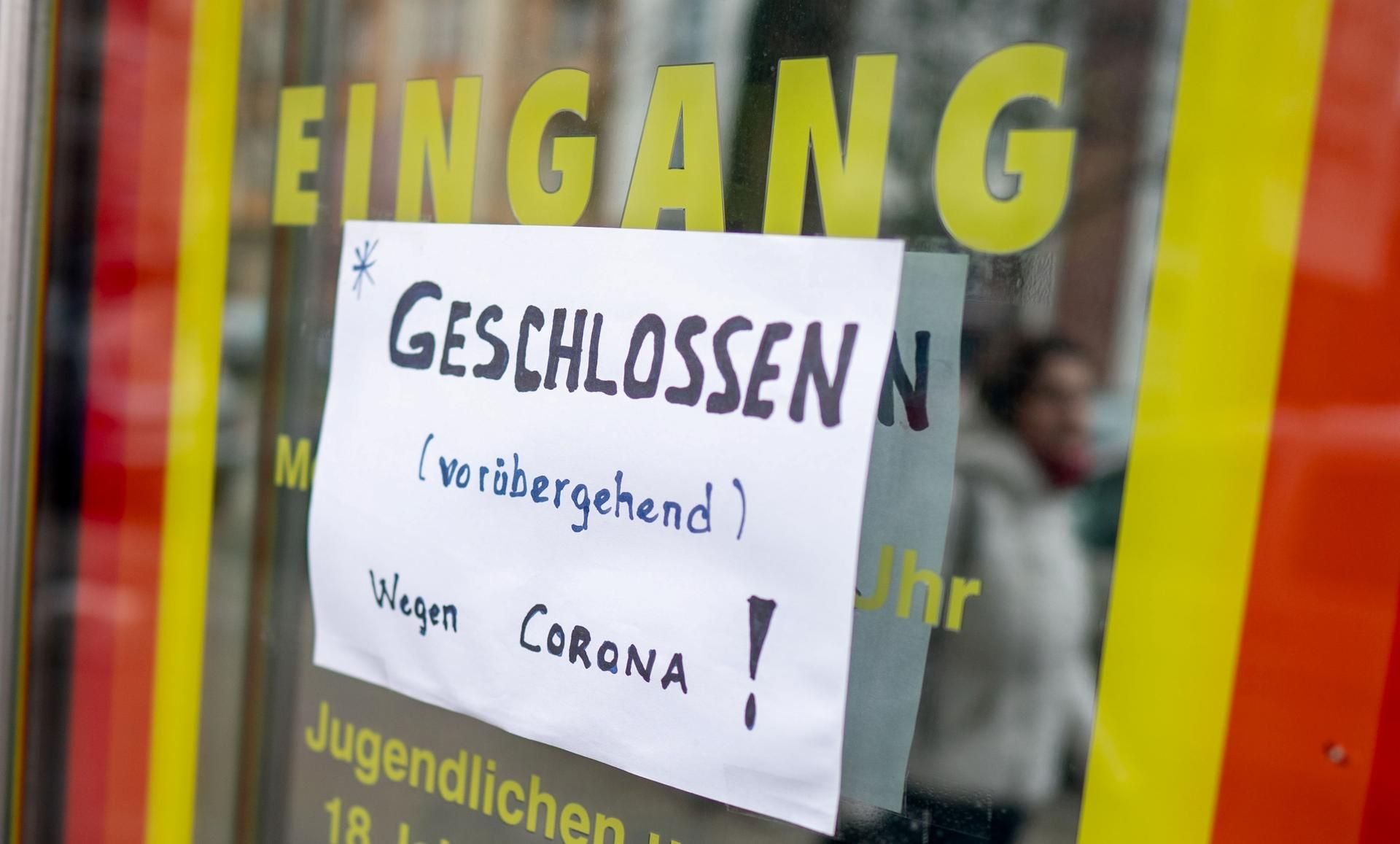 Ein Zettel mit der Aufschrift: „Geschlossen (vorübergehend) wegen Corona!“ an der Tür einer Spielhalle.