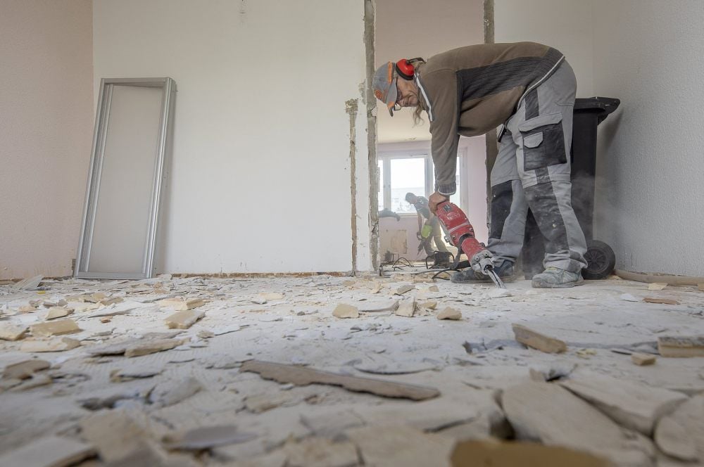 Bauarbeiter entfernen den Estrich aus den Wohnungen am Ballenstedter Pestalozziring 31-33.