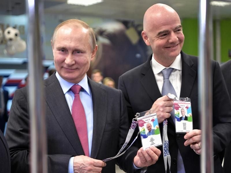 Russlands Präsident Wladimir Putin (l) und FIFA-Präsident Gianni Infantino zeigen beim Betreten eines Stadions ihre Fan-ID. Foto: Alexei Nikolsky/POOL SPUTNIK KREMLIN/AP