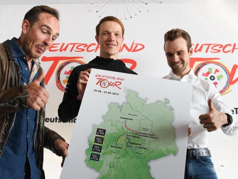 Die Radprofis John Degenkolb (l-r), Nikias Arndt und Maximilian Schachmann zeigen eine Karte mit den Stationen der diesjährigen Deutschland-Tour. Foto: Arne Dedert/dpa