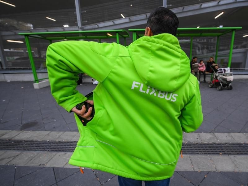 Ein Flixbusmitarbeiter steht vor zwei Wartehäuschen. Foto: Andreas Arnold/Archiv