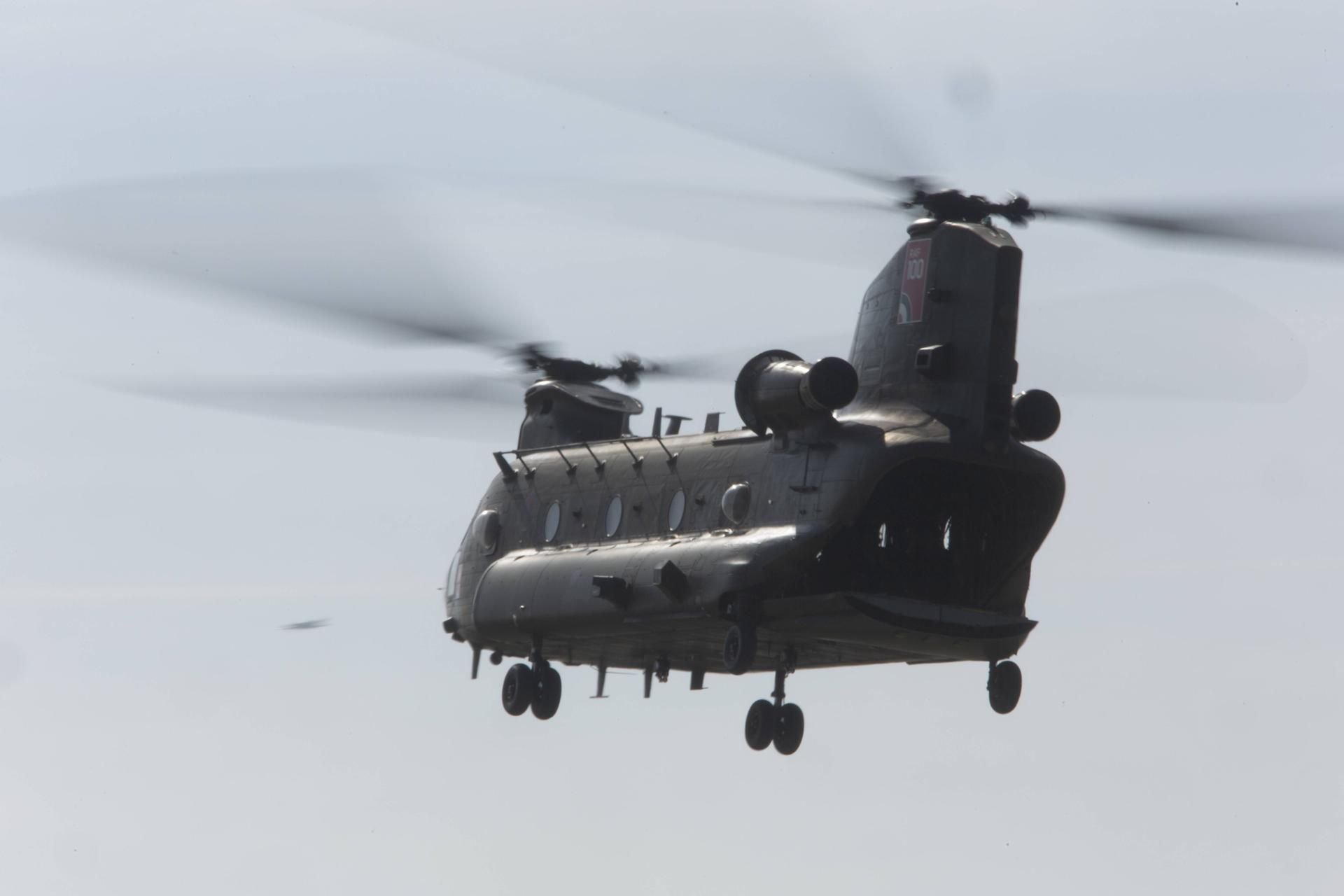 Ein Hubschrauber vom Typ Chinook schwebt über dem Boden