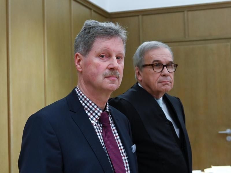 Klemens Olbrich (l), Bürgermeister von Neukirchen, steht zu Prozessbeginn im Amtsgericht neben seinem Anwalt Karl-Christian Schelzke. Foto: Uwe Zucchi/dpa/Archivbild