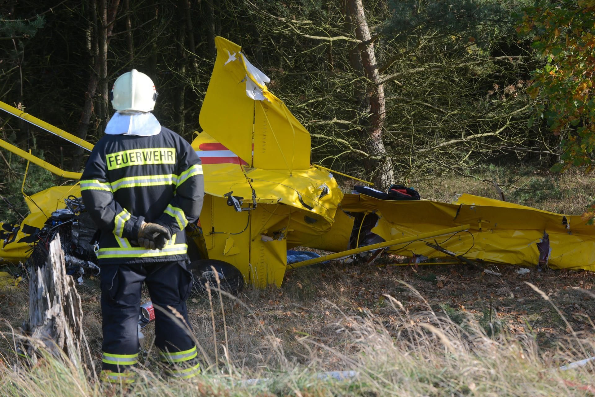 Ein Feuerwehrmann steht nach dem Absturz eines Kleinflugszeugs nahe Jüterbog (Brandenburg) am Unfallort.