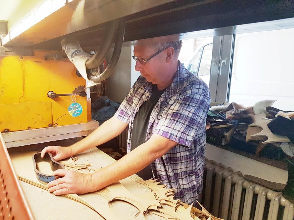 Peter Weiß stanzt Filzsohlen an der Stanzmaschine