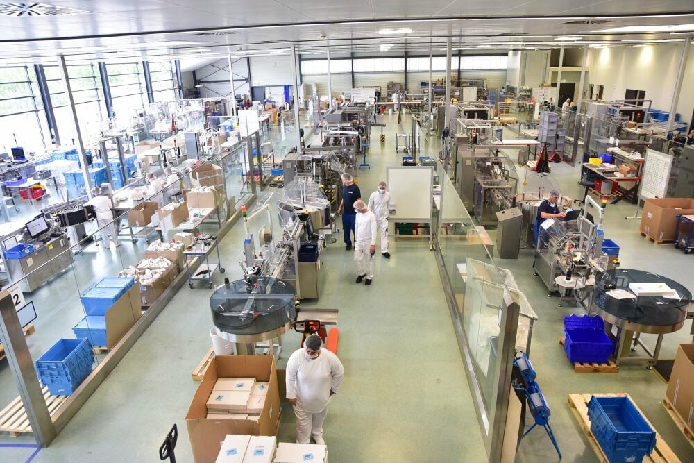 Blick in die große Halle, in der die Medikamentenflaschen oder Ampullen voll- und halbautomatisch, aber auch per Hand verpackt werden.