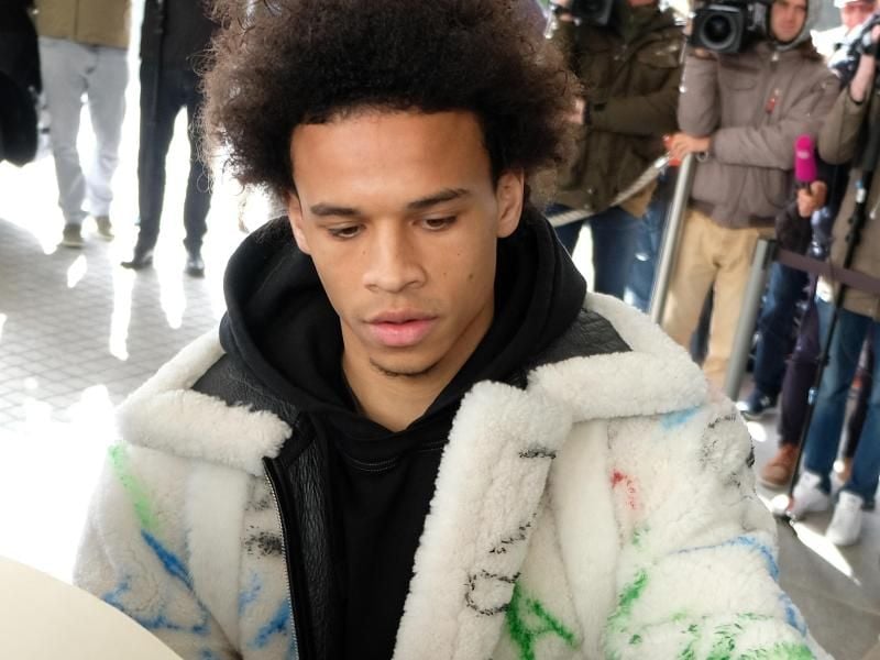 Leroy Sané in seiner auffallenden Jacke bei der Ankunft der Fußball-Nationalmannschaft in Wolfsburg. Foto: Peter Steffen