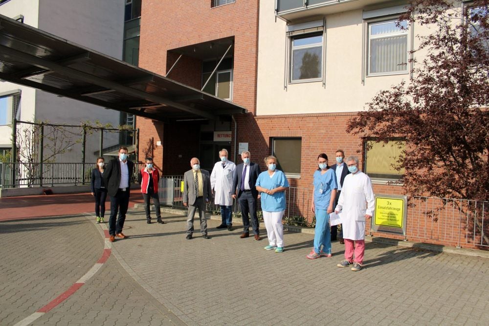 Mitglieder der Krankenhaus-Task-Force gemeinsam mit Landrat Jürgen Dannenberg, Amtsärztin Beate Wetzel und Oberbürgermeister Torsten Zugehör stehen auf der Fläche neben der Rettungsstelle, wo das Sondernotaufnahme-Zelt künftig stehen wird.