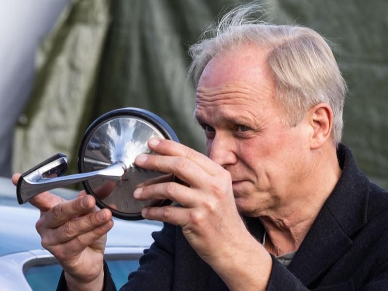 Schauspieler Ulrich Tukur blickt am Set für einen neuen Tatort in einen Autospiegel. Foto: Frank Rumpenhorst/Archivbild
