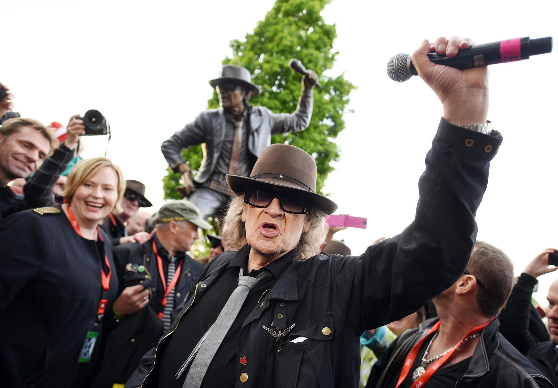 Udo Lindenberg posiert zur Enthüllung eines Denkmals für ihn vor der Bronzefigur in Gronau.