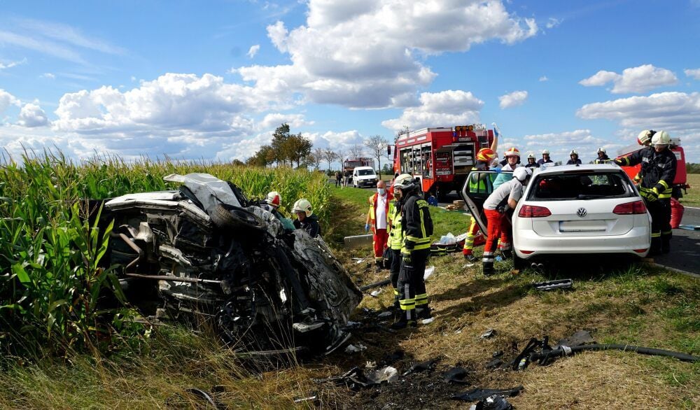 Feuerwehrleute bergen am Unfallort zwischen Aschersleben und Hoym die Fahrer aus den zerstörten Autos.