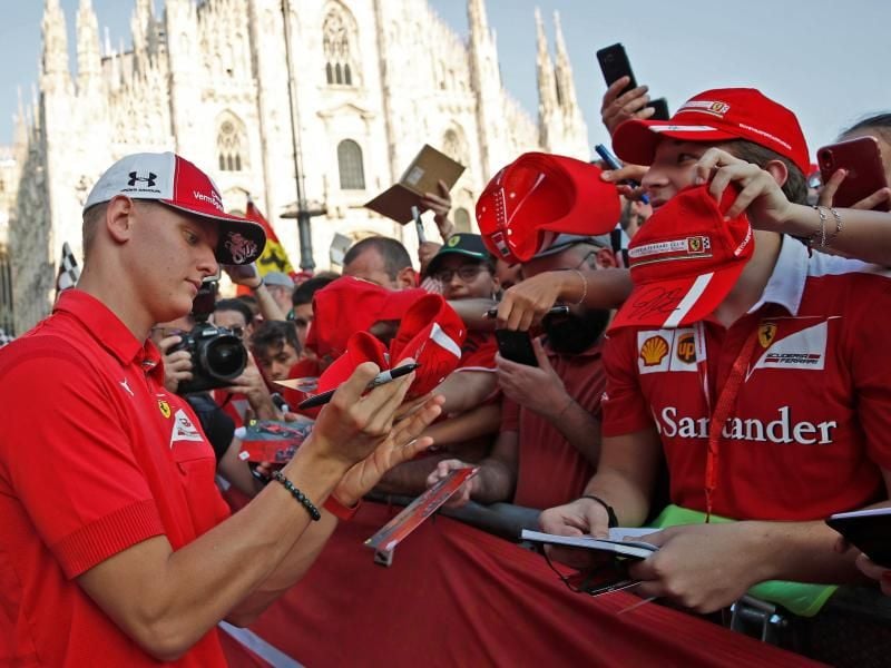Mick Schuhmacher schreibt während der Feierlichkeiten zum 90. Geburtstag der Scuderia Ferrari in Mailand Autogramme. Foto: Antonio Calanni/AP