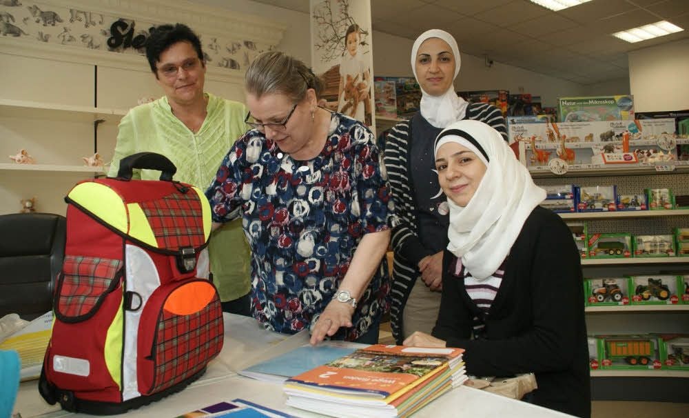 Cornelia Müller (links) begleitet Rem Ajami und Hiba Zaki beim Schuleinkauf und Heidrun Schwier packt die Sachen ein.