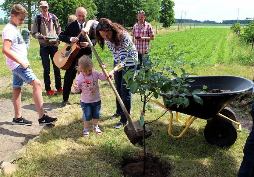Amelie hilft der Heporö-Geschäftsführerin Simone Rohde in Zemnick beim Pflanzen des kleinen Apfelbaums der Sorte Boskoop.