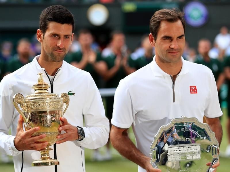 Sichtlich erschöpft stehen Titelverteidiger Novak Djokovic (l) und sein Finalgegner Roger Federer bei der Siegerehrung zusammen. Foto: Mike Egerton/PA Wire