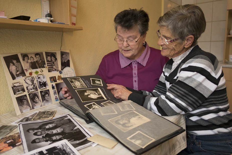 Ursula (li.) und Karin stöbern in alten Fotoalben nach Kindheitserinnerungen.