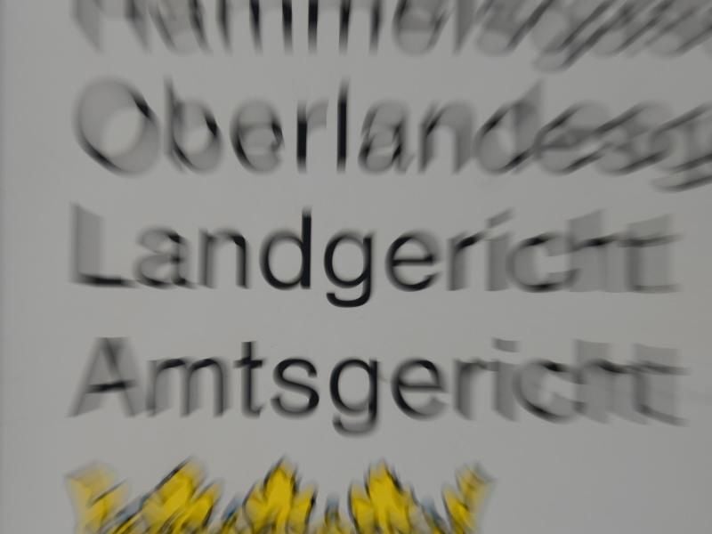 Ein Schild mit der Aufschrift „Oberlandesgericht”, „Landgericht” und „Amtsgericht”. Foto: Arne Dedert/dpa/Archivbild