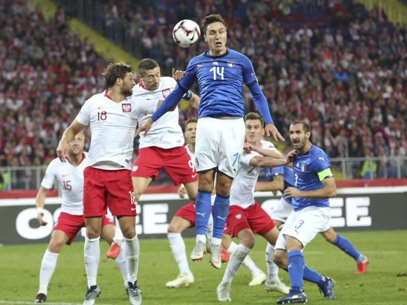 Polens Bartosz Bereszyński (l) und Robert Lewandowski (M) und Italiens Federico Chiesa (M) steigen hoch zum Ball. Foto: C. Sokolowski/AP
