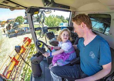 Karsten König besichtigt mit Tochter Lilly (4) einen Mähdrescher der Agrargesellschaft.