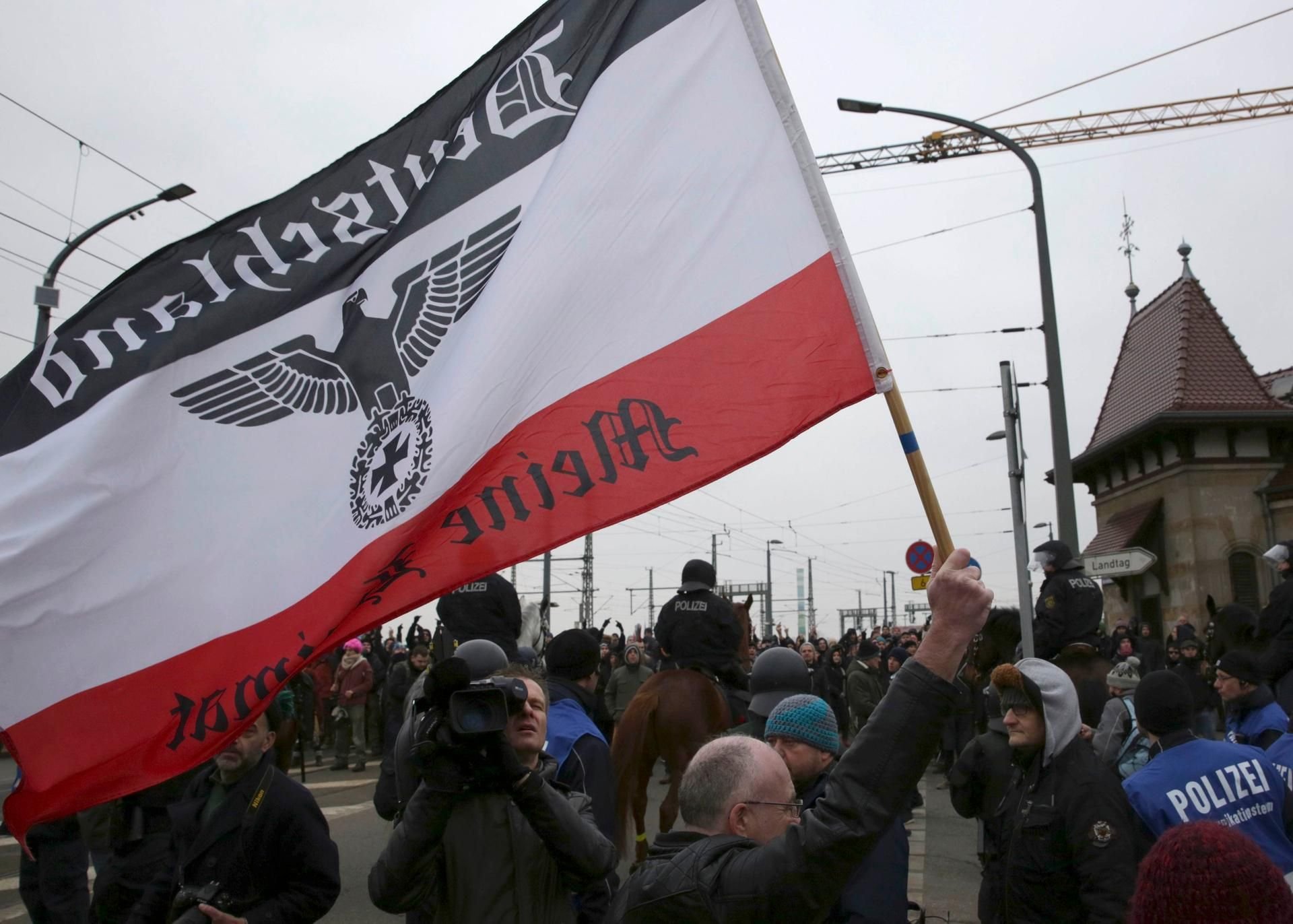 Gerhard Ittner bezeichnet den Holocaust indirekt als die „größte Lüge der Weltgeschichte“. Hier schwenkt er eine rechtspopulistische Flagge.