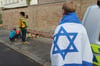 Ein Mann mit einer Israel-Flagge vor der Synagoge in Halle.