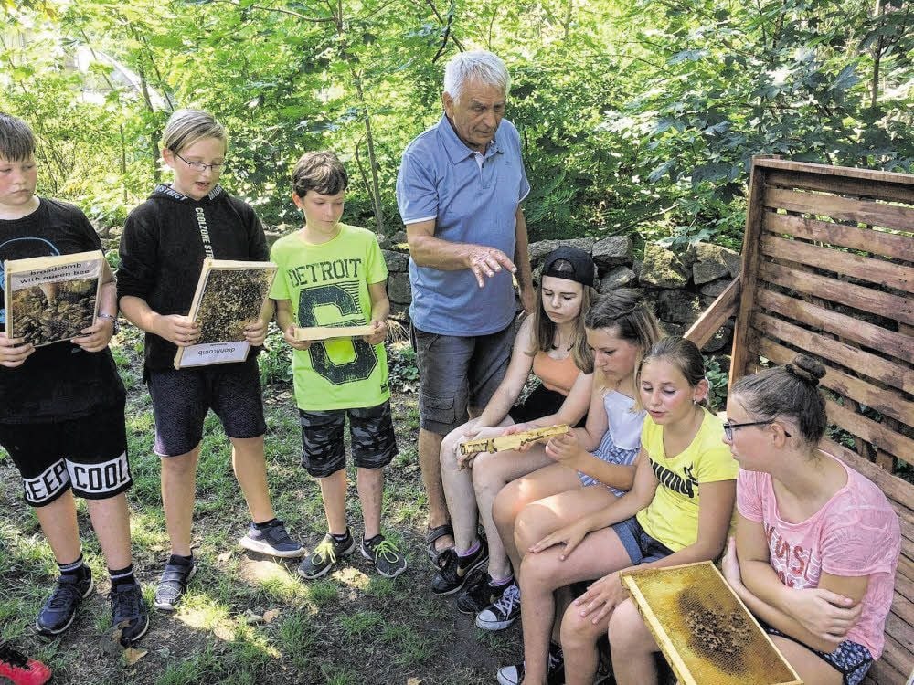 Bernd Berger erklärt Schülerinnen und Schülern im „Grünen Daumen“, wie Bienen arbeiten und miteinander interagieren.
