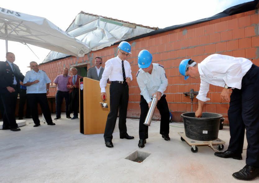 Grundsteinlegung fürs neue Feuerwehrgerätehaus Linda. Ortswehrleiter Hartmut Lange versenkt die Hülse, Siegfried Borgwardt und Michael Jahn mauern sie ein.