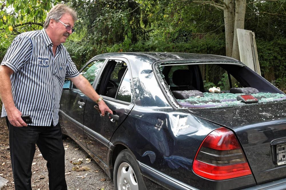 Conny Freystadtl vor seinem zerstörten Auto. Er kauft sich kein neues, aus Furcht, dass auch dieses zu Schrott geschlagen wird.