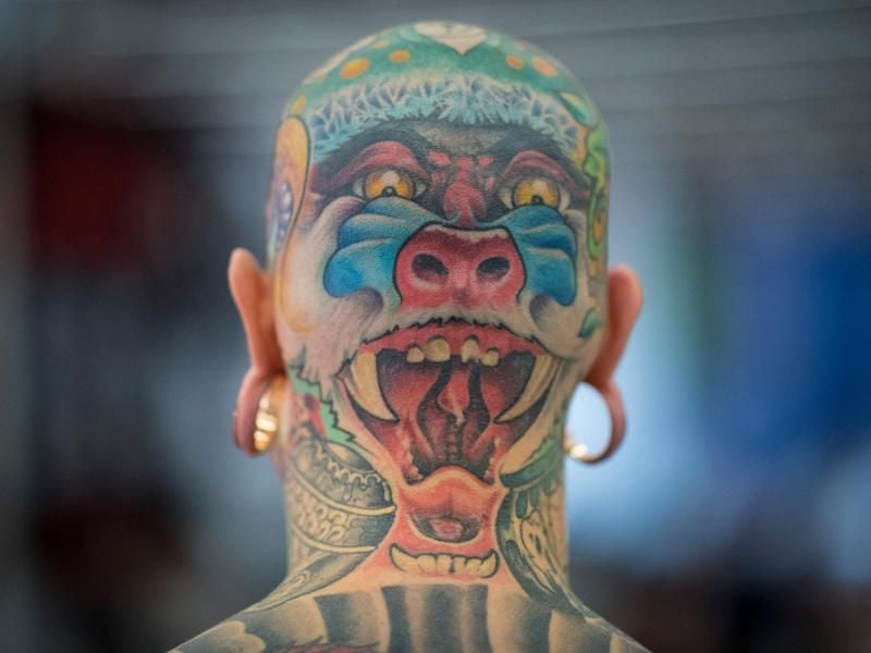 Ein Dämonengesicht ziert den Hinterkopf eines Mannes auf der Tattoo-Convention. Foto: Boris Roessler