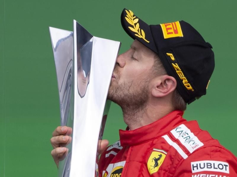 Sebastian Vettel küsst auf dem Podium in Montréal seine Siegestrophäe. Foto: Paul Chiasson/The Canadian Press/AP