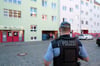 Ein Polizist steht in der Nähe einer Kindertagesstätte in Leipzig. Nach Diskussionen um die Änderung des Speiseplans hatte sich die Polizei eingeschaltet.