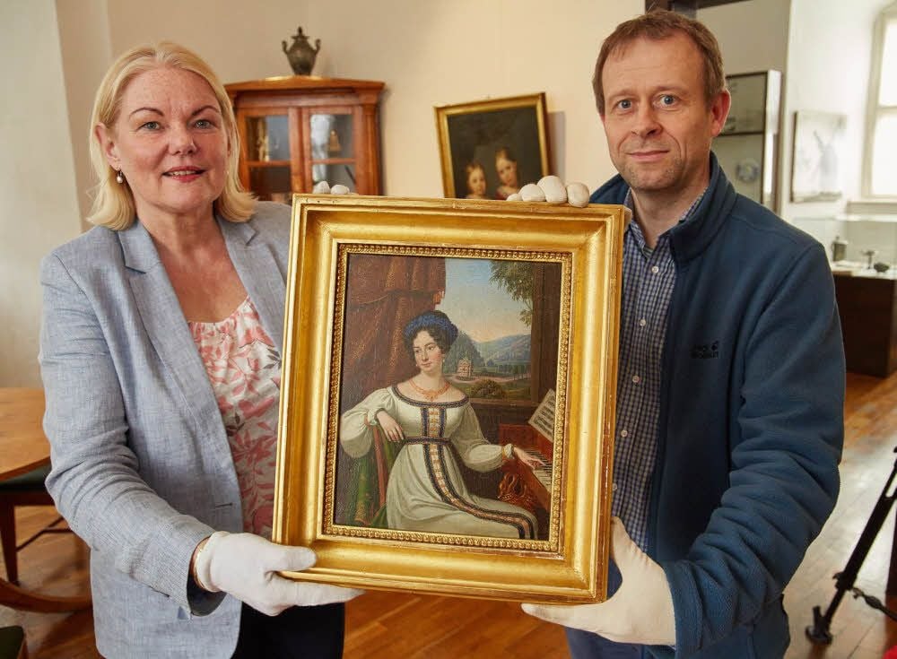 Bettina Fügemann vom Akzente-Verein übergibt Museumsdirektor Roland Wiermann das Gemälde.