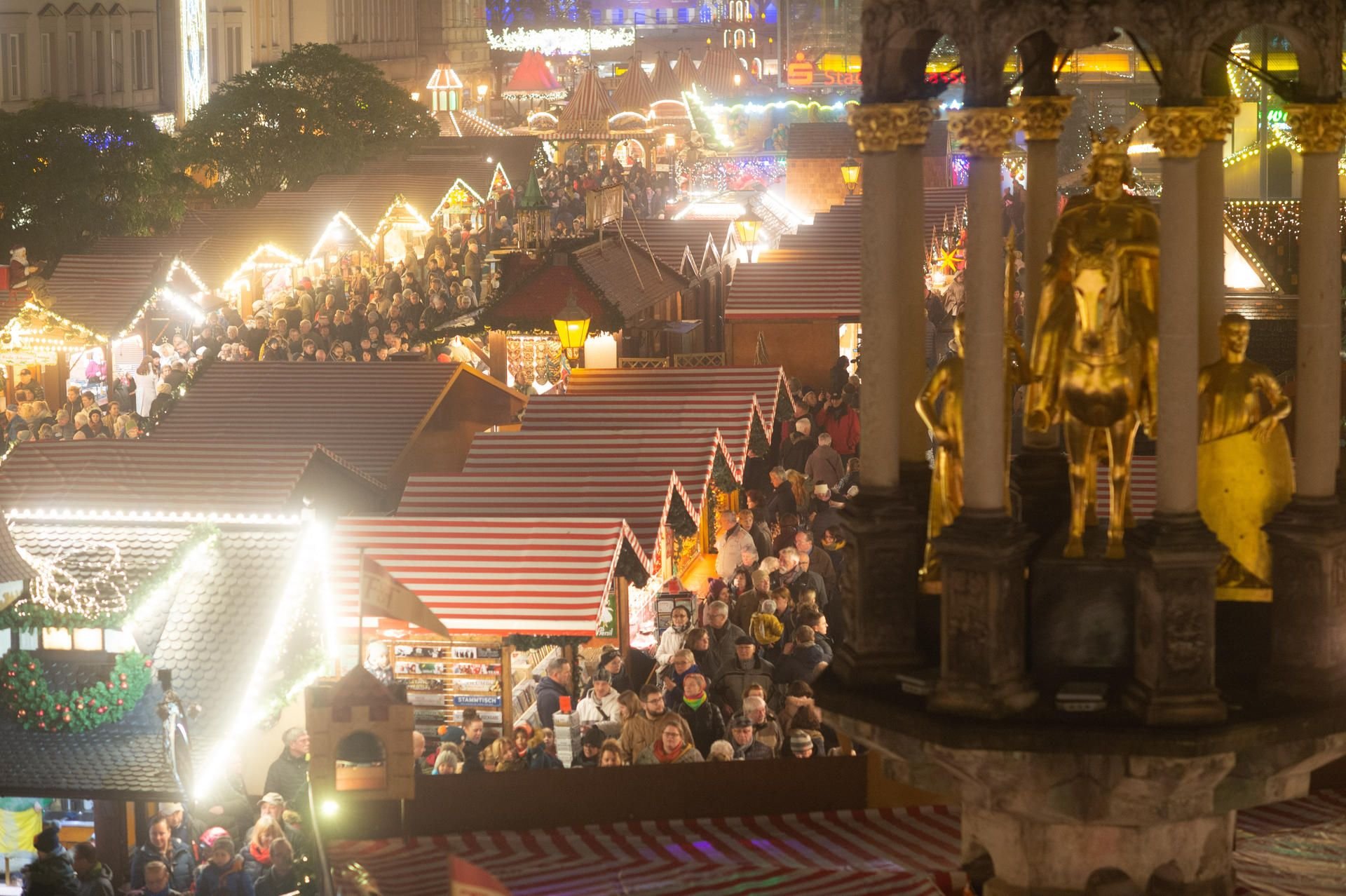 Besucher gehen über den festlich beleuchteten Magdeburger Weihnachtmarkt. Dieser hatte am späten Nachmittag eröffnet und dauert bis zum 30. Dezember 2019.