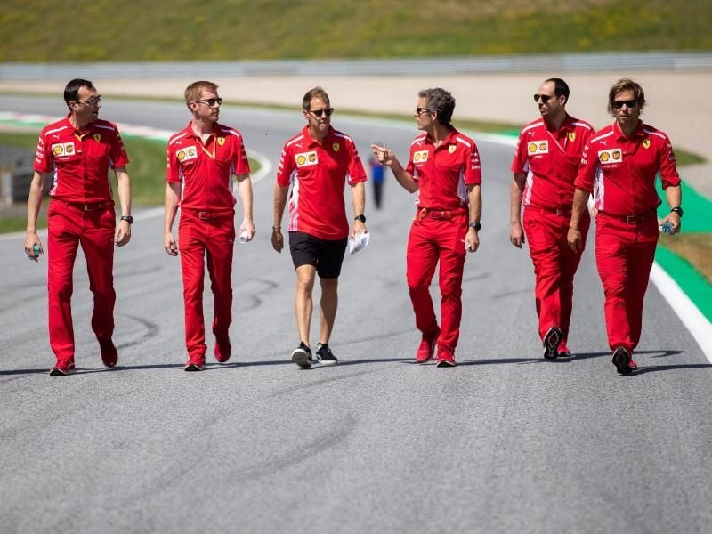 Sebastian Vettel (M) geht mit seinem Team die Rennstrecke in Spielberg ab. Foto: Georg Hochmuth/APA/APA