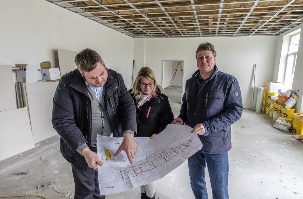 Bürgermeister Enrico Schilling, Julia Brückner vom Bauamt und Planer Uwe Geyer (v. l.) sehen sich den Plan der neuen Kita an. Die komplette Fertigstellung der Einrichtung soll im August abgeschlossen sein.