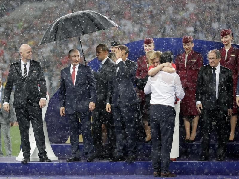 Bei der Siegerehrung im Luschnikistadion lässt Russlands Präsident Wladimir Putin (2.v.l.) alle anderen im Regen stehen. Foto: Matthias Schrader/AP