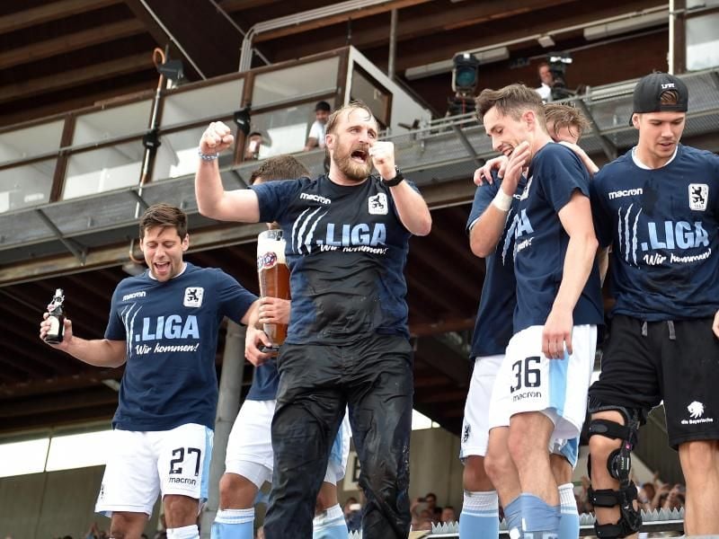 1860-Trainer Daniel Bierofka (M) und seine Spieler feiern den Aufstieg in die 3. Liga. Foto: Angelika Warmuth
