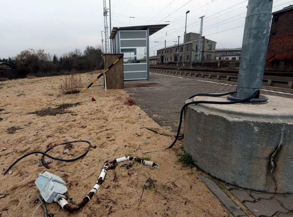 Blick aufs Holzdorfer Bahnhofsgelände. Kabel der Lampen liegen oberirdisch herum.