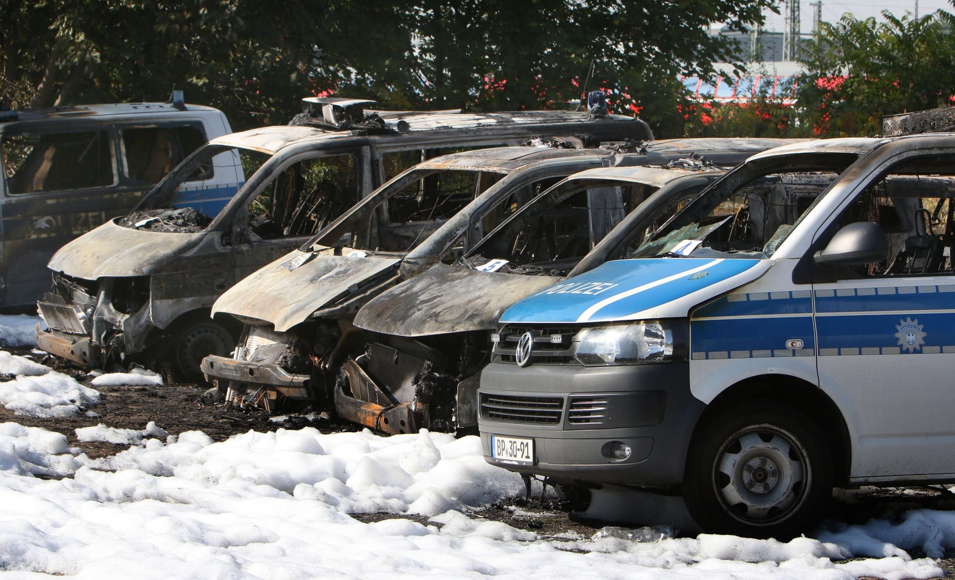 Ausgebrannte Polizeifahrzeuge stehen am 08.09.2016 auf einem Parkplatz am Hauptbahnhof in Magdeburg.