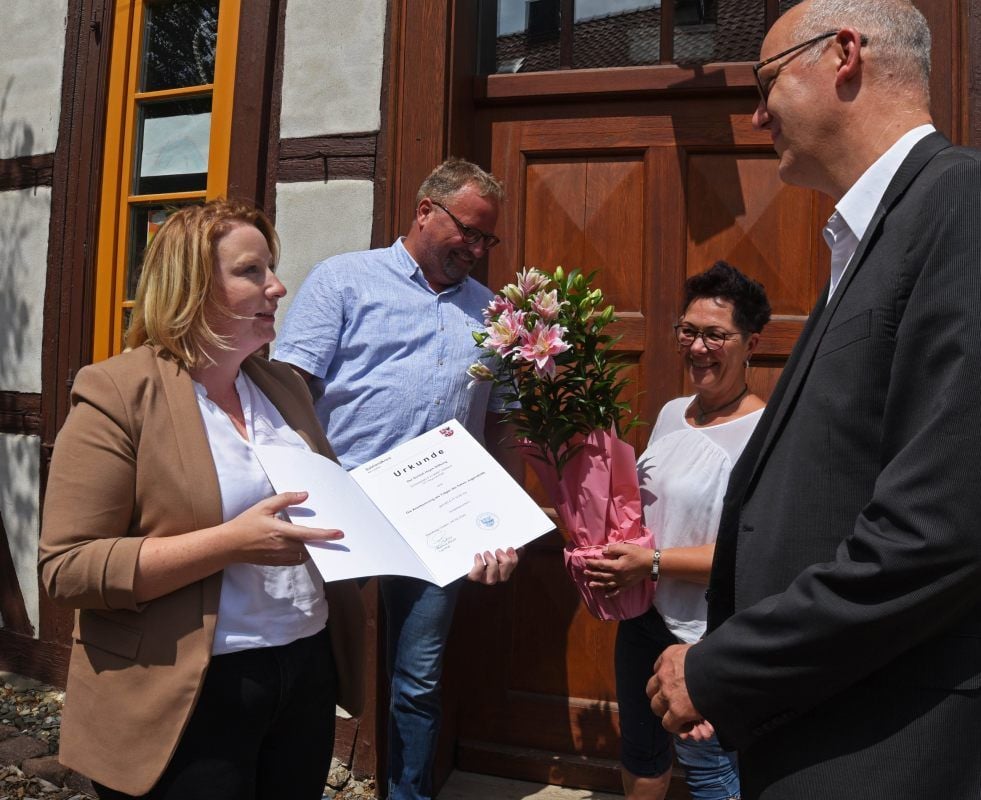 Josephin Rosinski vom Fachdienste Jugend und Familie überreicht am Schloß Hoym die Urkunde.