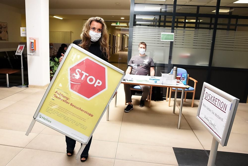 Helios-Sprecherin Johanna Lässing entfernt das Stoppschild am Eingang der Notaufnahme. Ab sofort dürfen wieder Besucher ins Krankenhaus.