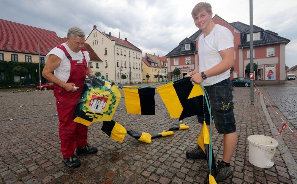 Auf dem Markt in Jessen wurden am Dienstag die Ketten mit der Beleuchtung angebracht. Die einzelnen Stränge laufen am Maibaum zusammen. Erledigt wurden die Arbeiten von der Elektro-Firma Hintersdorf. Thomas Liebig (links) und Georg Hintersdorf kümmerten sich mit darum.