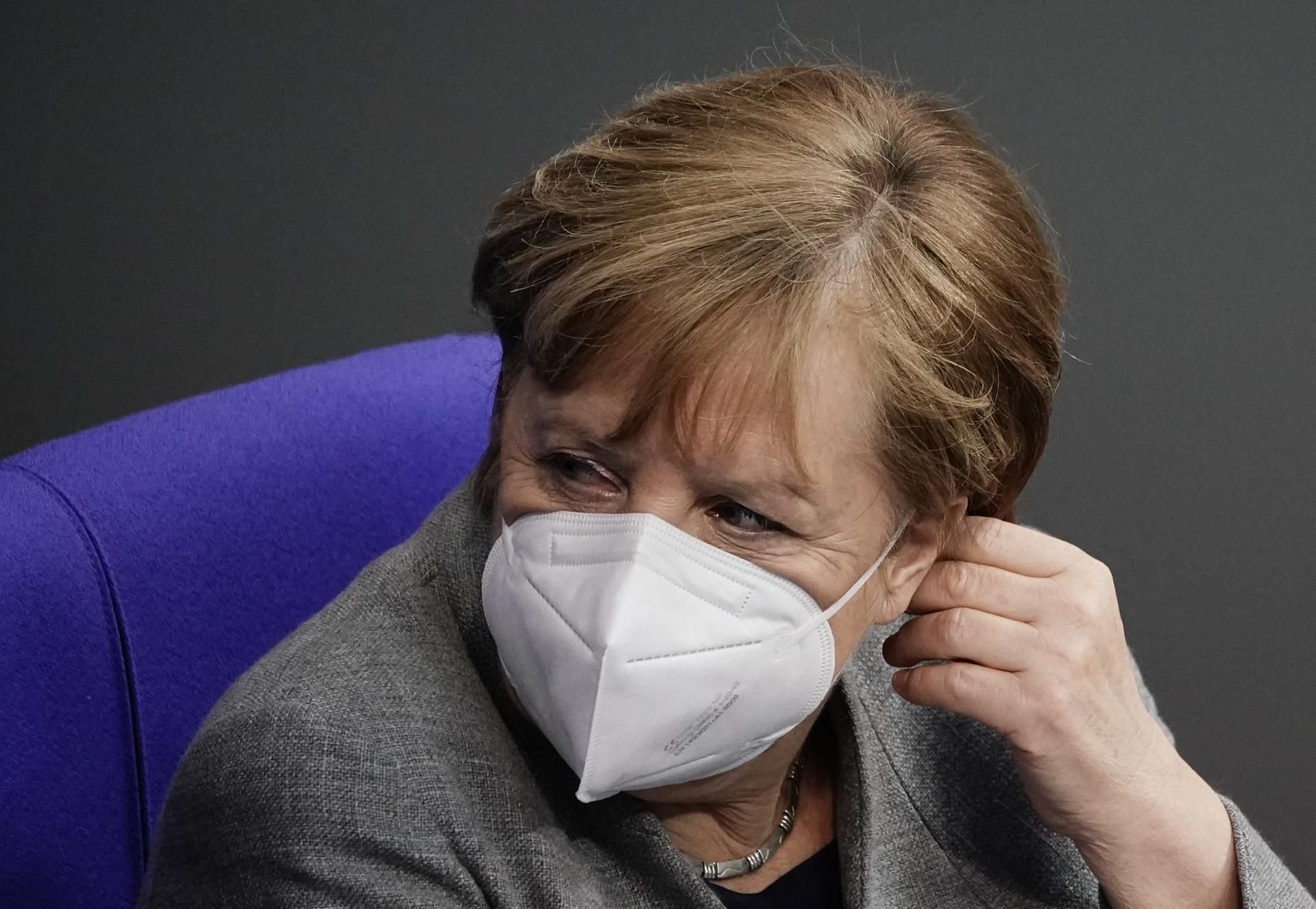 Bundeskanzlerin Angela Merkel (CDU) verfolgt mit FFP2-Maske eine Debatte zu Corona-Impfungen im Bundestag.
