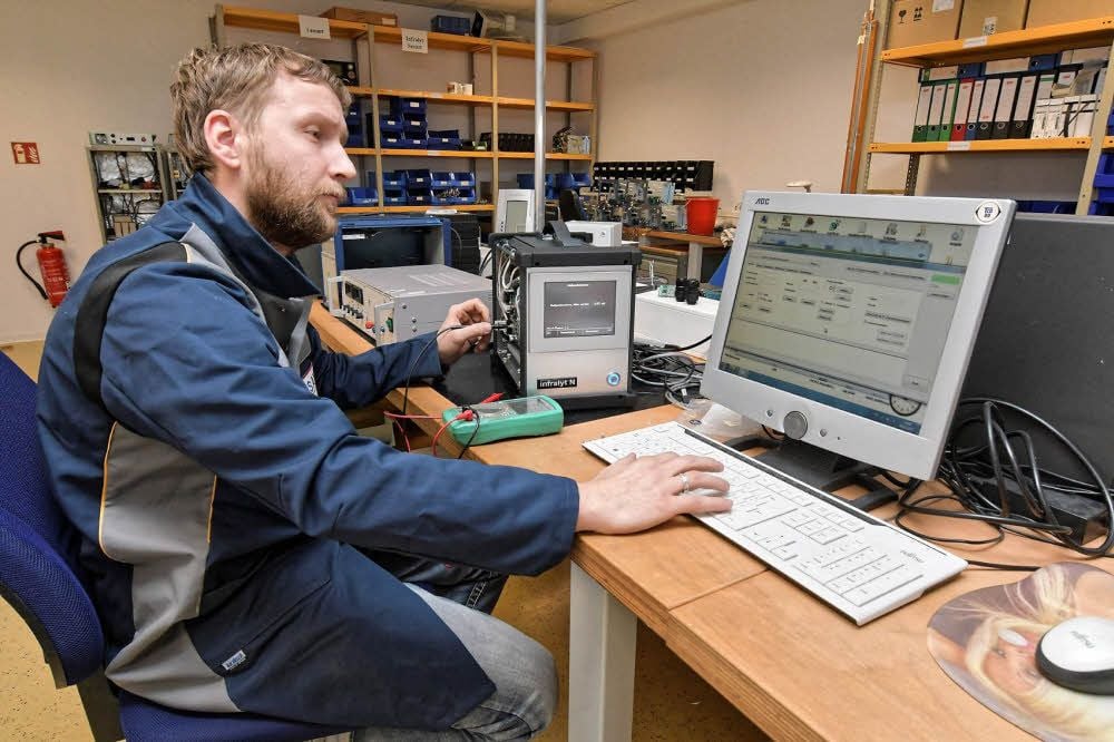 Elektroniker Stefan Machulka richtet ein Abgasmessgerät für Dieselfahrzeuge ein.
