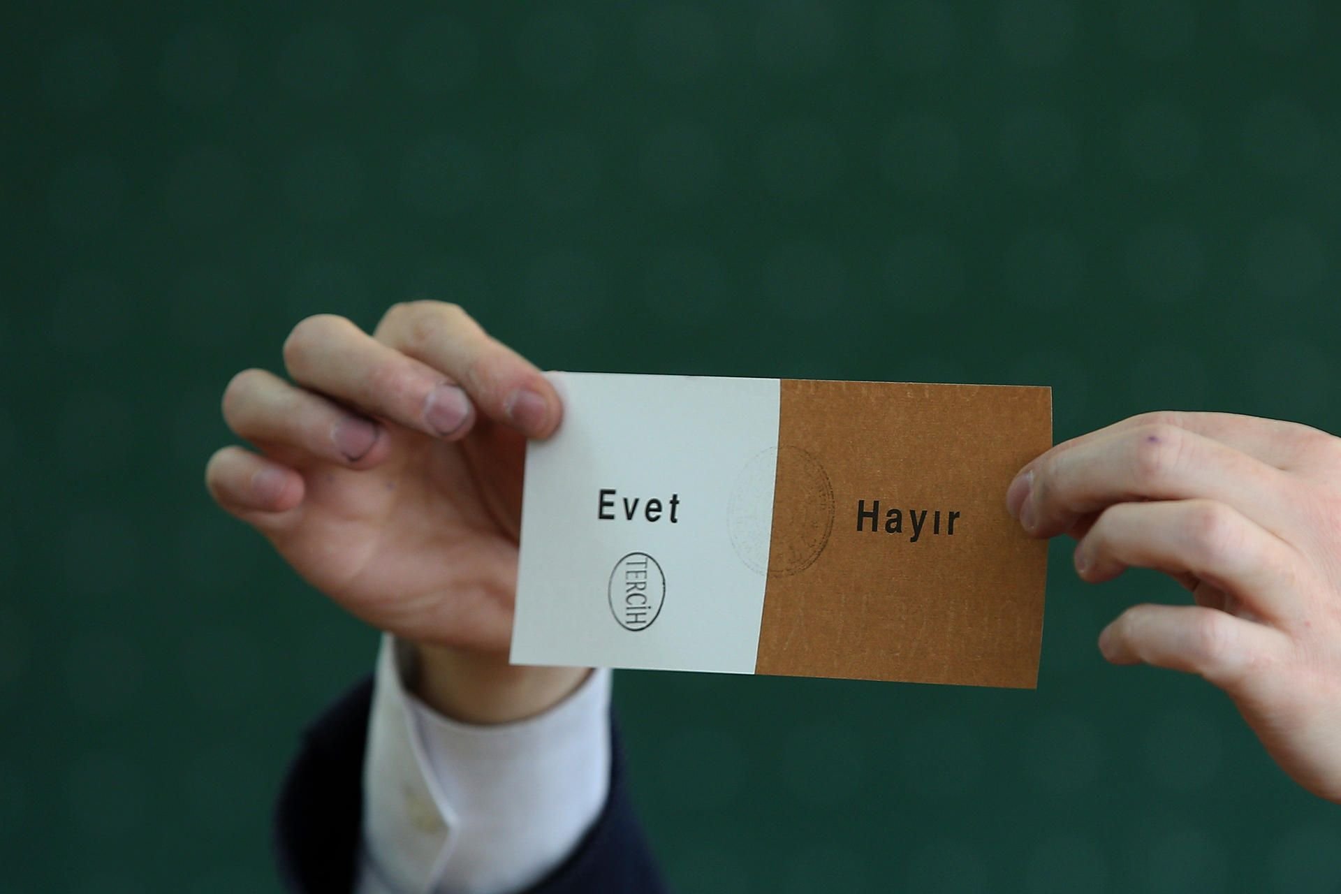 Ein Mitglied eines Wahlkomitees hält in Istanbul (Türkei) in einem geschlossenen Wahllokal bei der Auszählung einen mit „Evet“ („Ja“) abgestempelten Stimmzettel hoch.
